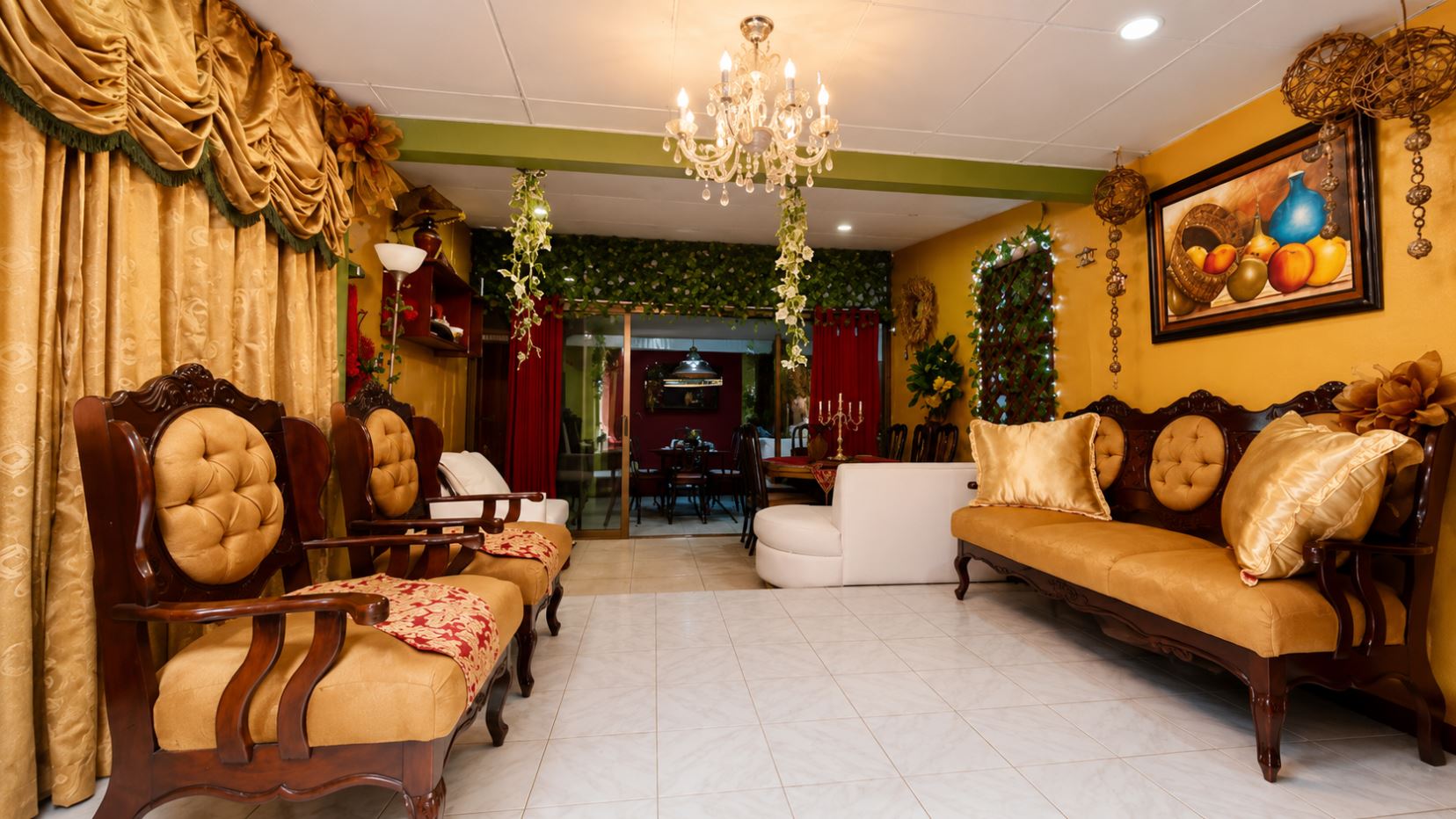Elegant gold-toned lounge with tufted wooden chairs, matching sofa, and lush drapes under a chandelier.